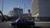 Un automóvil antiguo pasa por la Embajada de los Estados Unidos con una bandera cubana. (REUTERS/Alexandre Meneghini)