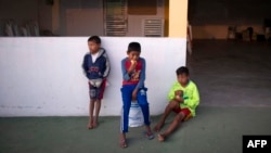 Niños toman su desayuno en las afueras de una iglesia en la frontera con Brasil.