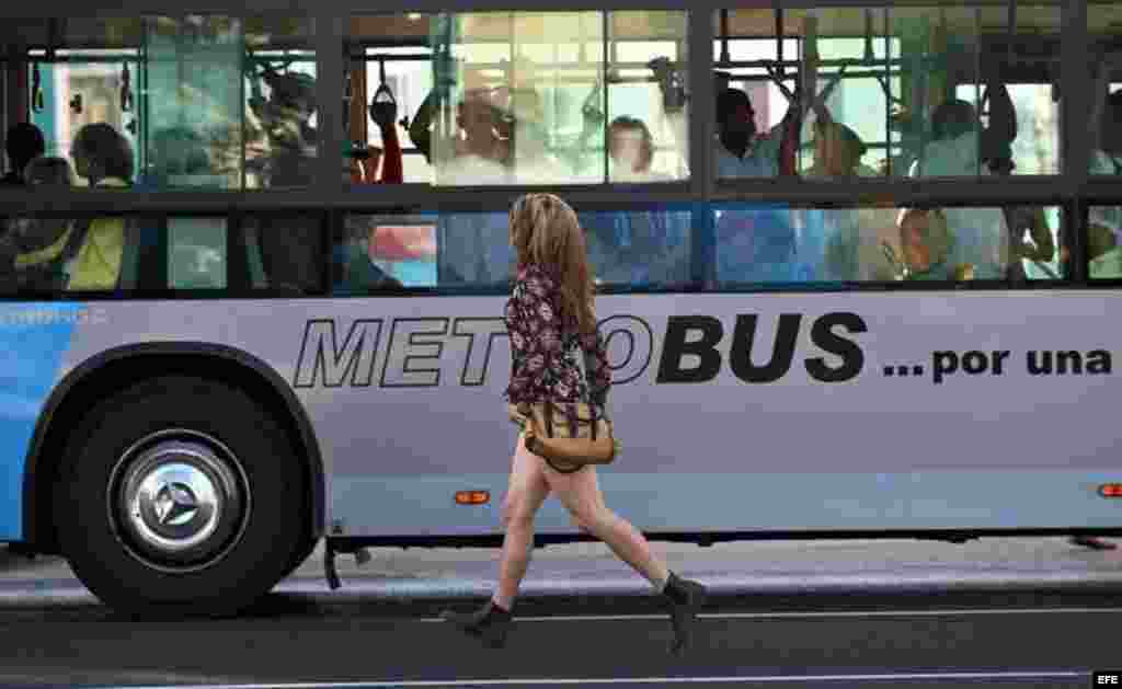 Una joven corre para alcanzar un autobús en La Habana (Cuba), este viernes, 20 de enero de 2017, día en que el magnate estadounidense Donald Trump asume la presidencia de EEUU.  