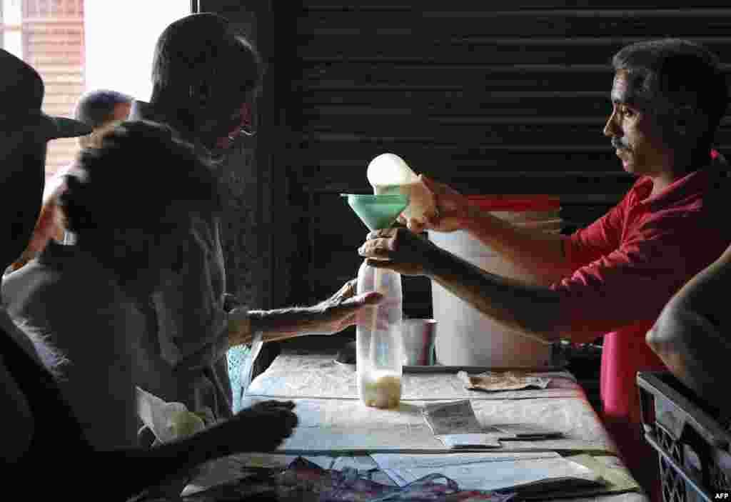Un hombre compra leche en una bodega de Cuba. Un tercio de la población come dos o menos veces por día.  AFP PHOTO / STR
