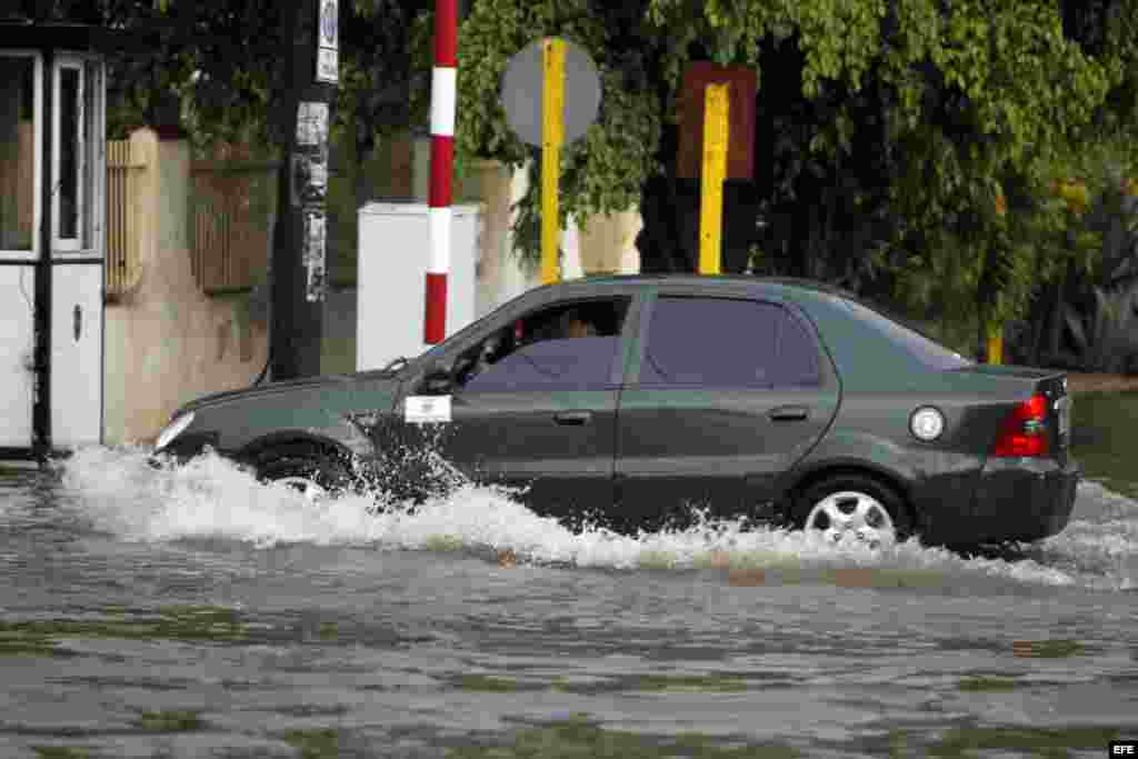 Un vehículo cruza por una calle inundada hoy, miércoles 29 de abril de 2015, en La Habana (Cuba).