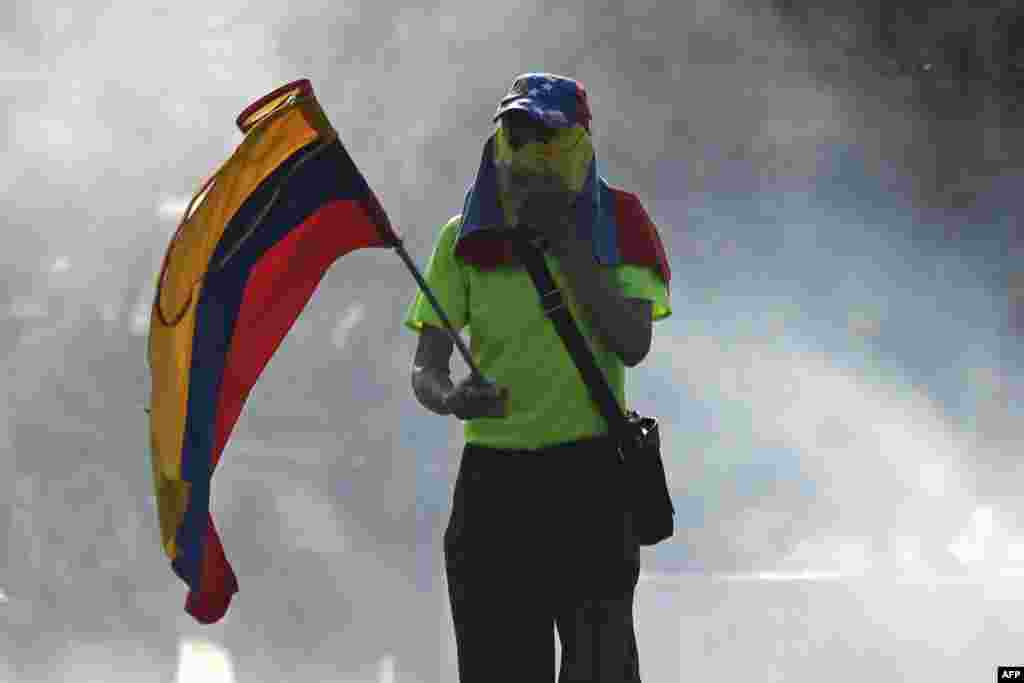 Un opositor sostiene una bandera venezolana durante las manifestaciones en Caracas contra Nicolás Maduro.