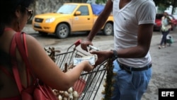 Una mujer compra cebollas con pesos cubanos en La Habana (Cuba).