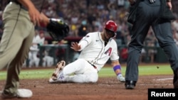 El jardinero de los Diamondbacks de Arizona Lourdes Gurriel Jr. (12) se desliza en casa y anota una carrera contra los Padres de San Diego durante la sexta entrada en el Chase Field, 27/ 09/2024 Phoenix, Arizona, EE.UU. (Foto Joe Camporeale-Imagn Images)