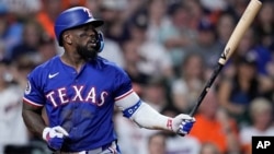 Adolis García, de los Rangers de Texas, batea durante la tercera entrada en partido de béisbol contra los Astros de Houston el 2 de abril de 2024. (AP Foto/Kevin M. Cox)