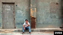 Un jombre permanece sentado junto a un cartel alusivo al presidente cubano Fidel Castro, en La Habana.