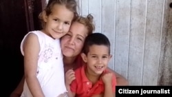 Lázara Yairis García Cruz, con sus dos hijos.