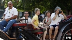 Turistas pasea en un coche tirado por caballos
