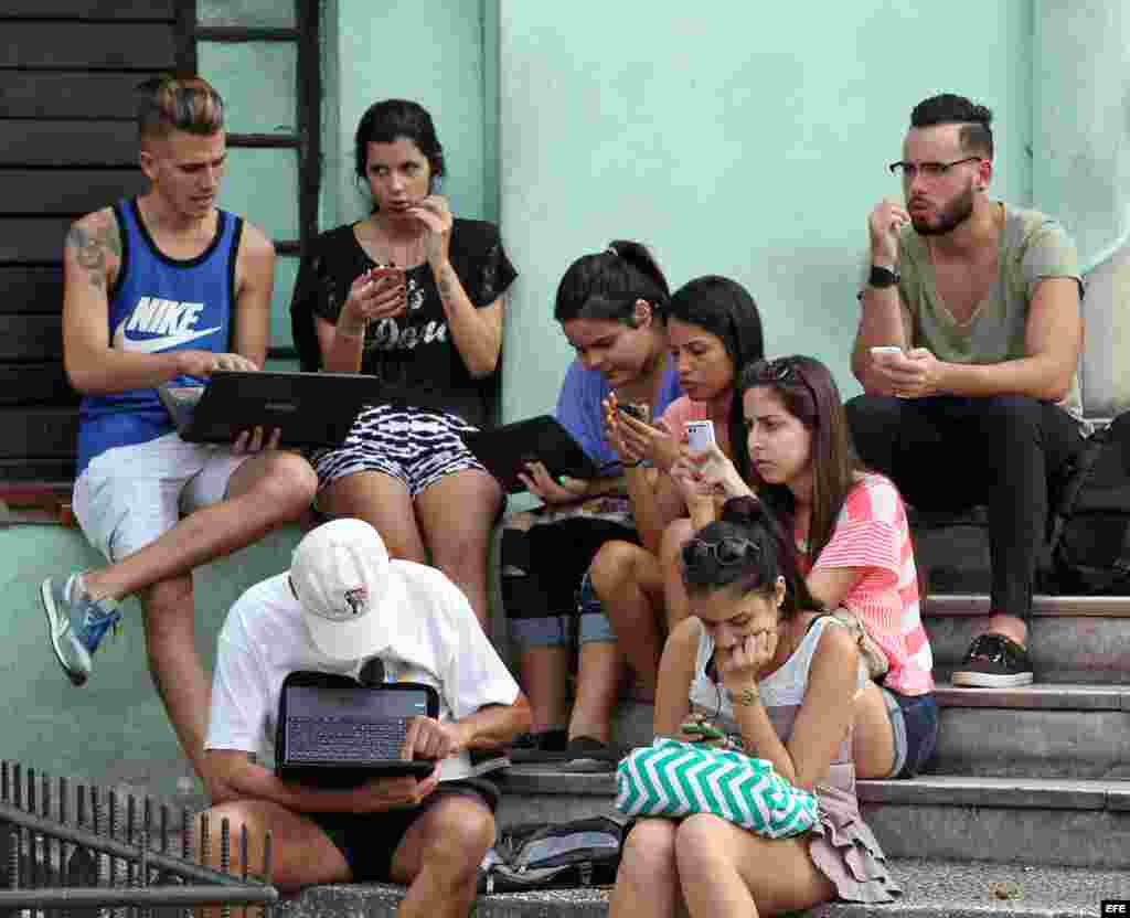 Un grupo de jóvenes se conectan a internet en una zona WiFi, en La Habana.