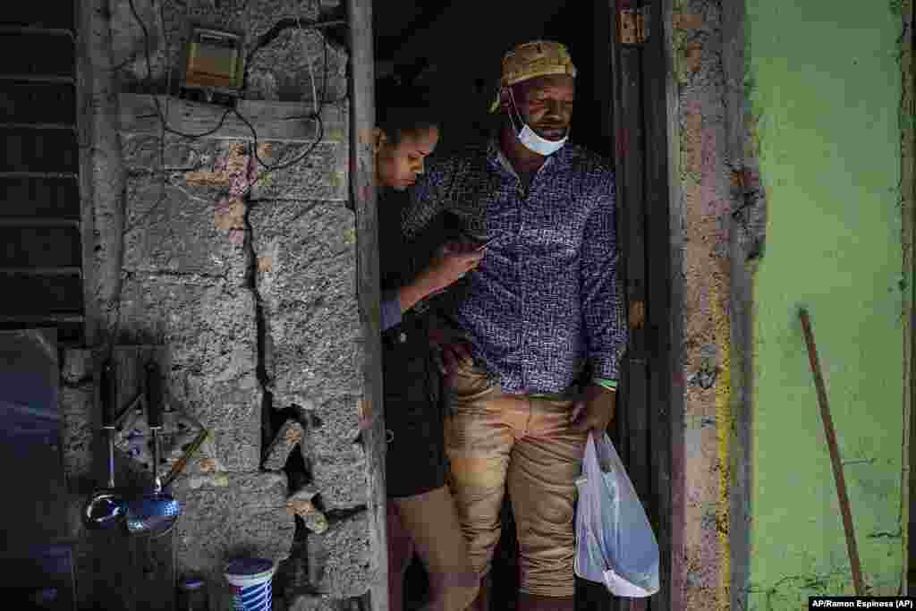 Emilio Román, padre de dos jóvenes y una hija que se encuentran en prisión acusados de participar en las recientes protestas contra el gobierno, posa con su nuera María Carla Milan Ramos en su casa del barrio habanero La Güinera.