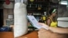 Un hombre espera comida en una tienda mientras sostiene una "libreta".