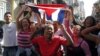 impatizantes del Gobierno cubano gritan consignas revolucionarias mientras el grupo de mujeres Las Damas de Blanco.