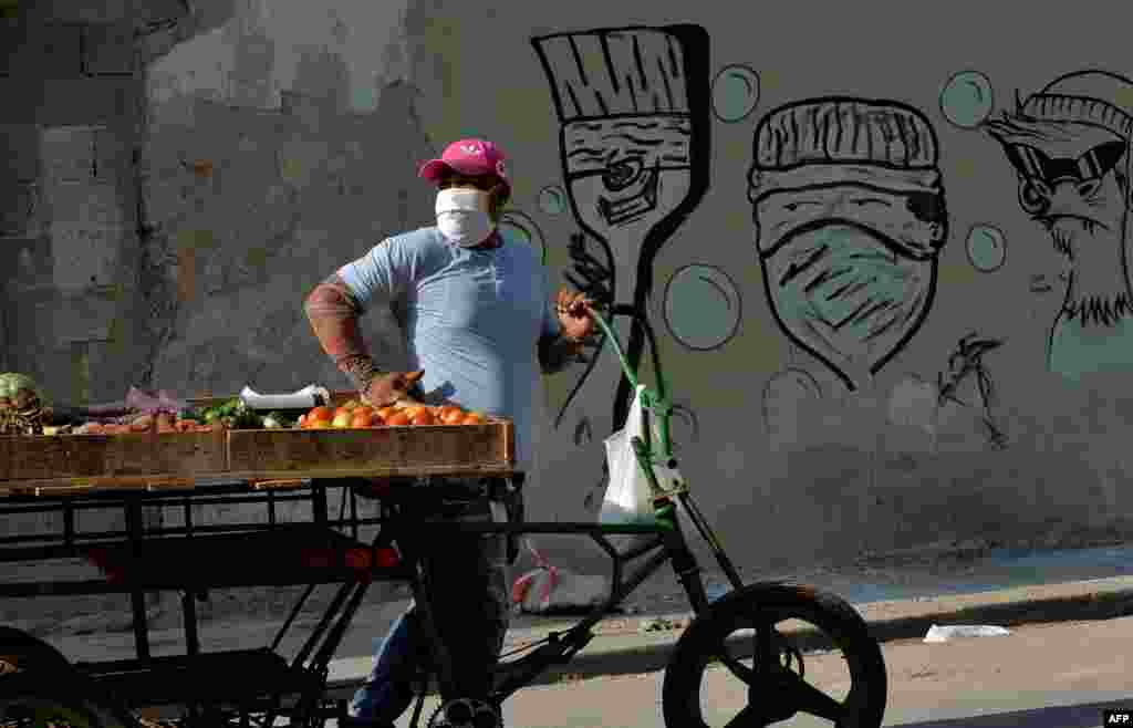 Un vendedor de vegetales en una calle de La Habana usa una máscara para protegerse del coronavirus. (YAMIL LAGE / AFP)