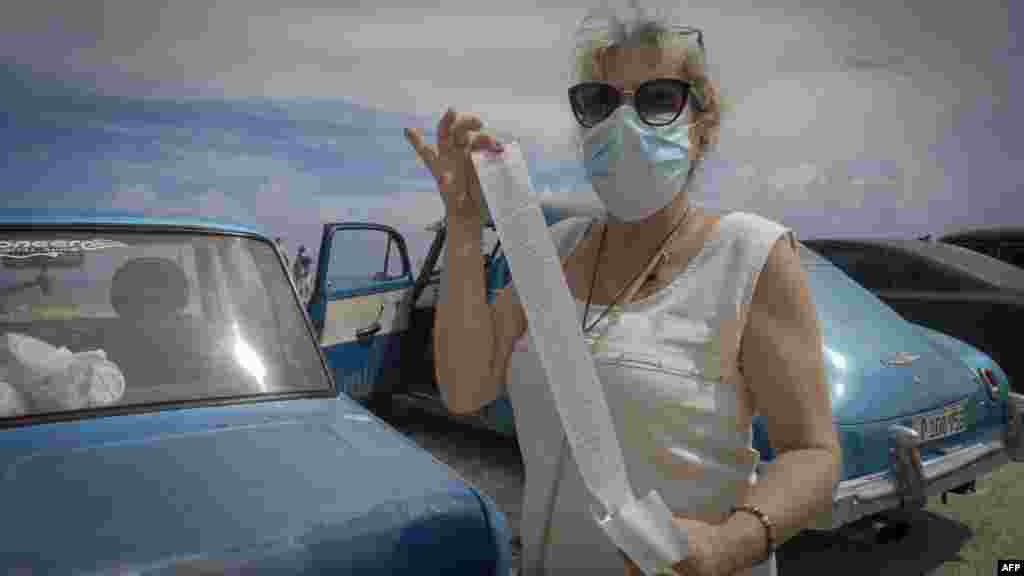 Cubana enseña el comprobante de ventas tras comprar en tienda usando dólares.