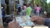 Un hombre muestra un peso convertible cubano y un dólar estadounidense frente a una oficina de la Western Union en La Habana.
