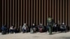 Migrantes de Venezuela y Cuba detenidos por la patrulla fronteriza de EEUU después de cruzar la frontera desde México en Yuma, Arizona el 17 de febrero de 2022.