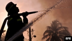 Bomberos cubanos intentan sofocar un incendio