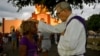 Un sacerdote bendice a un peregrino durante la procesión a El Rincón en adoración a San Lázaro. Yamil Lage/AFP