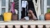Una mujer mira a la calle desde su balcón en La Habana. 