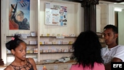 Tres jóvenes conversan en una farmacia en La Habana,Cuba.