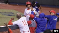 El jugador de los Alazanes de Granma de Cuba Raúl González (frente) festeja una anotación ante los Tomateros de Culiacán de México.