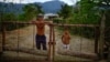 El campesino Javier Tamayo, 55, posa junto a su nieto en su casa en la Sierra Maestra. REUTERS/Alexandre Meneghini