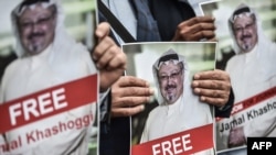 Manifestantes sostienen fotos del periodista saudí y colaborador del Washington Post Jamal Khashoggi.